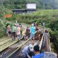 Warga bergotong royong membangun jembatan darurat dari bambu agar pejalan kaki dan roda dua tetap bisa lewat.