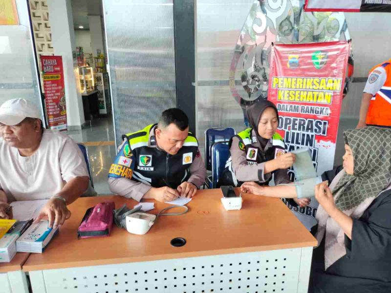 Petugas Subsatgas Dokkes Polres Wonosobo menggelar pelayanan kesehatan gratis di Pos Pelayanan Kesehatan Terminal Mendolo, Selasa (30/12/2025).