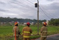 Petugas Damkar saat memadamkan travo yang terbakar.