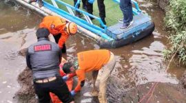 Petugas Polsek Garung saat mengevakuasi korban yang diduga tenggelam di Telaga Menjer.