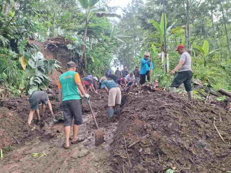 Warga bergotong royong membersihkan material tanah longsor.