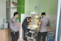 Petugas Polsek Sapuran melakukan pemeriksaan terhadap bayi perempuan yang ditemukan di pinggir Jalan Desa Batursari, Wonosobo.