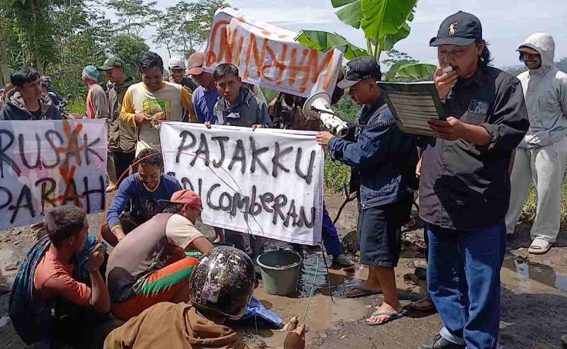 Puluhan warga menggelar aksi simbolik di ruas Jalan Kalibeber-Deroduwur tepatnya di Desa Derongisor, Kecamatan Mojotengah, Kabupaten Wonosobo, Sabtu (28/2/2026).